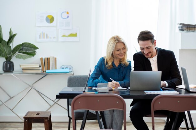 Personas sonrientes de tiro medio trabajando juntas