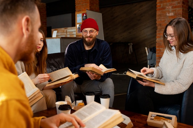 Foto gratuita personas sosteniendo libros tiro medio