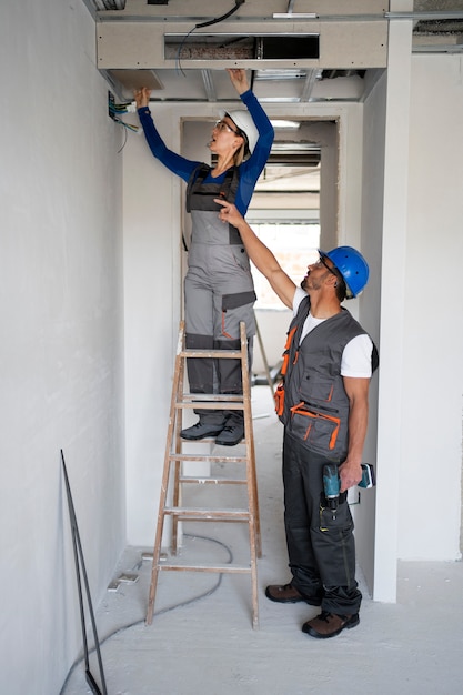 Foto gratuita personas de tiro completo con cascos de seguridad.