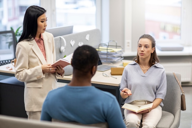 Personas de tiro medio aprendiendo juntas en la oficina