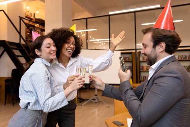 Personas de tiro medio celebrando cumpleaños en la oficina