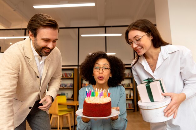 Personas de tiro medio celebrando con regalos.