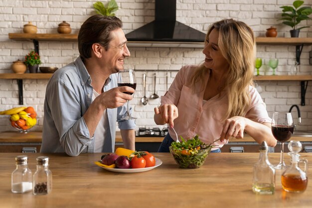 Personas de tiro medio con comida y vino.