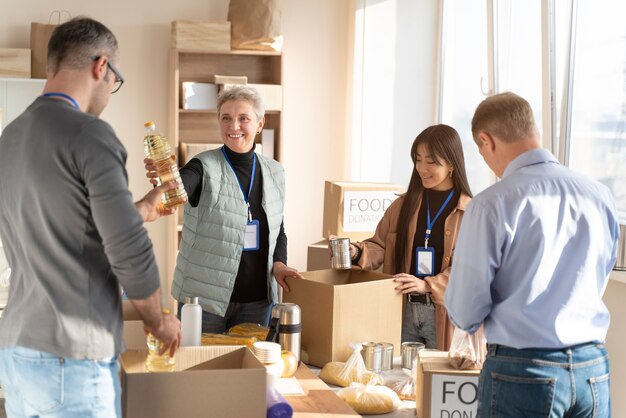 Personas de tiro medio con donaciones de alimentos.