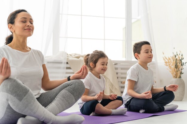 Personas de tiro medio en estera de yoga