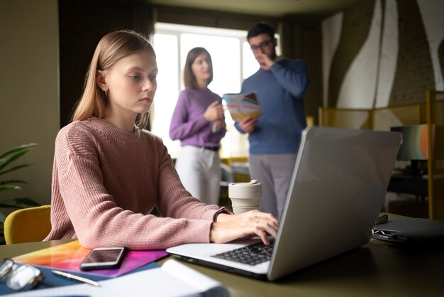 Personas de tiro medio que trabajan con una computadora portátil