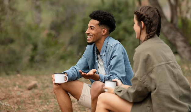 Personas de tiro medio con tazas al aire libre