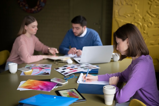 Foto gratuita personas de tiro medio trabajando en el escritorio