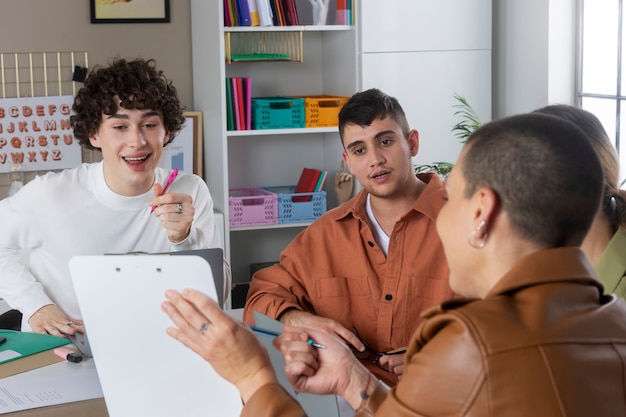 Personas de tiro medio trabajando juntas en el escritorio