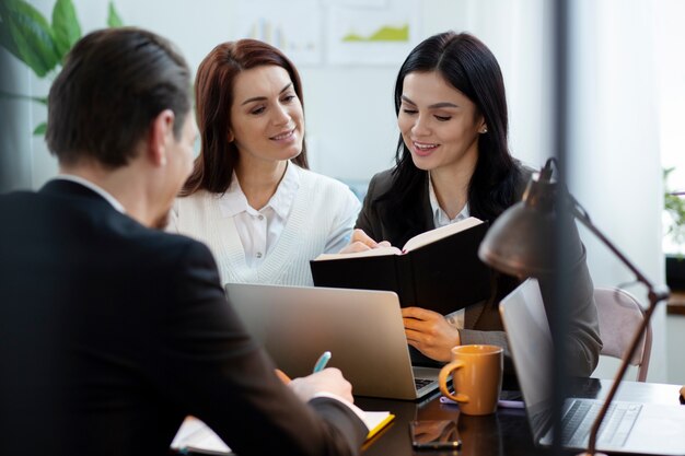 Personas de tiro medio trabajando juntas en la oficina