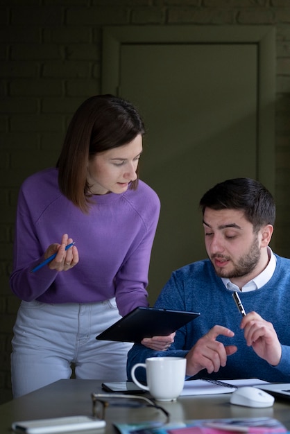 Personas de tiro medio trabajando juntas en la oficina