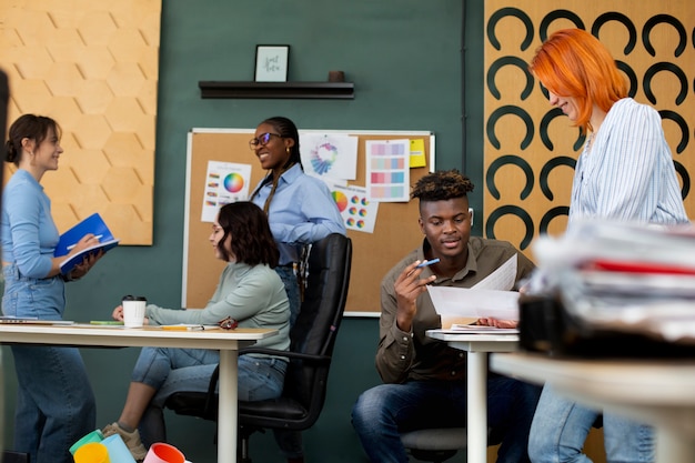 Personas trabajando juntas en la oficina plano medio