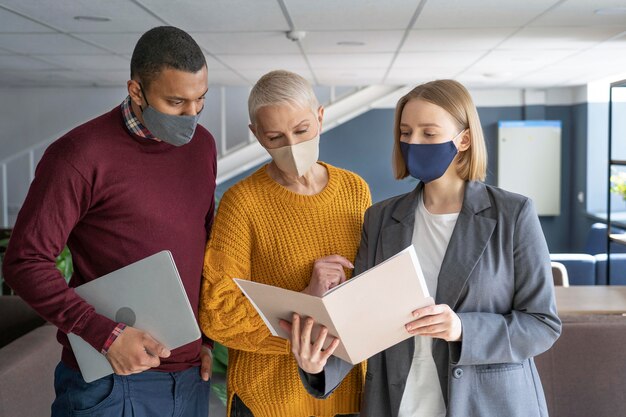 Personas en el trabajo con máscaras médicas.