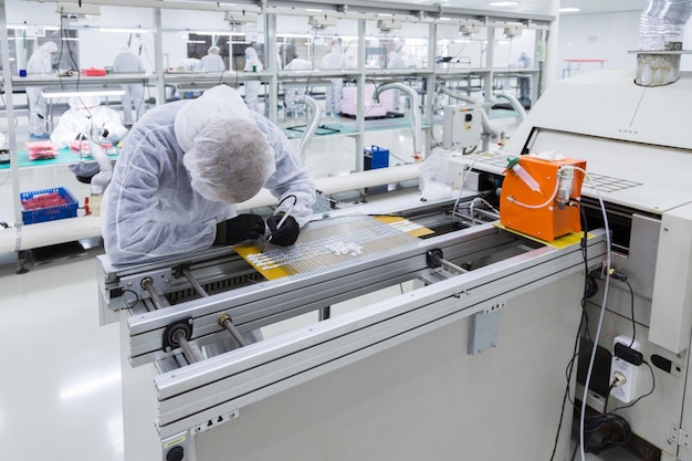 Personas en trajes aislantes blancos trabajando en laboratorio.