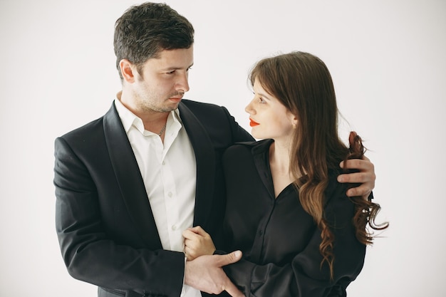 Personas vestidas con ropa clásica. Pareja elegante en un momento sensual sobre fondo blanco.