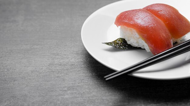 Pescado crudo de alto ángulo en un plato con palos