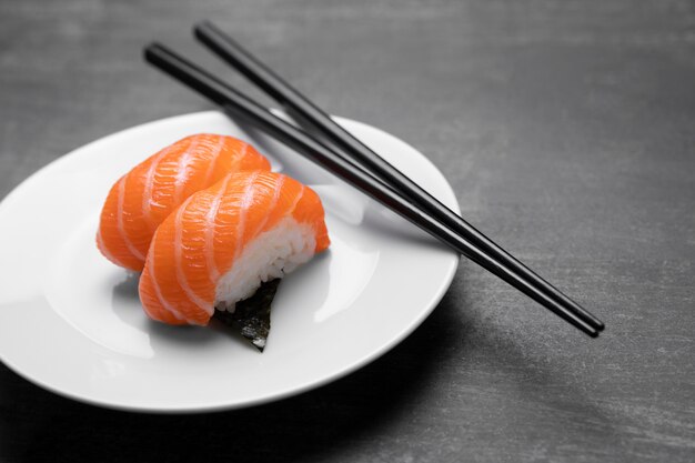 Pescado crudo en un plato con palos alto ángulo