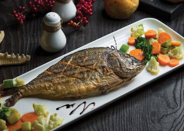 Pescado entero a la parrilla con ensalada de coliflor y zanahoria