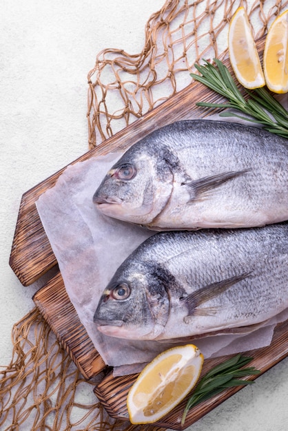 Pescado fresco besugo con rodajas de limón y red de pesca