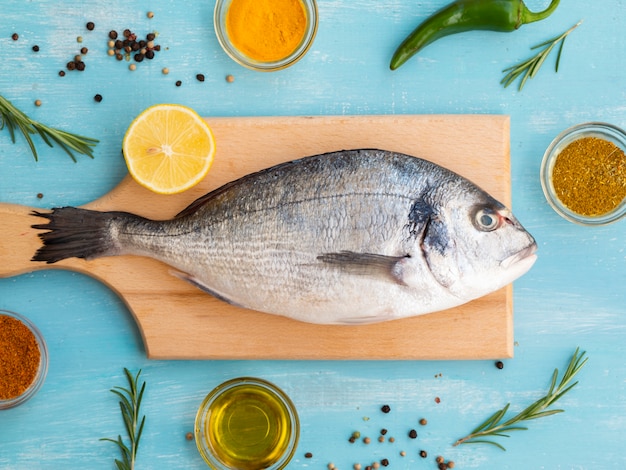 Foto gratuita pescado fresco tendido sobre una plancha de madera