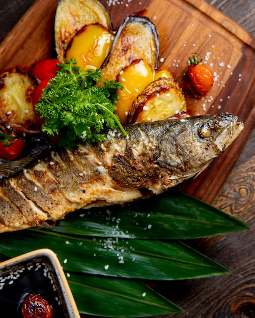 Pescado frito con berenjenas a la parrilla, pimientos y tomates