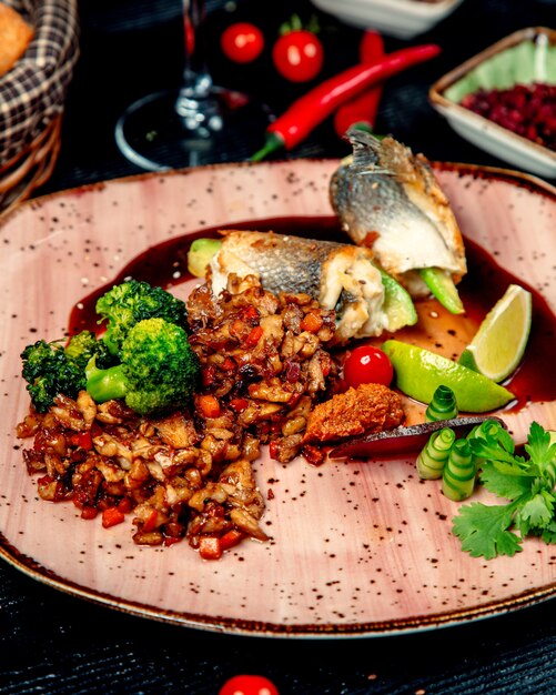 Pescado frito y carne con verduras sobre la mesa