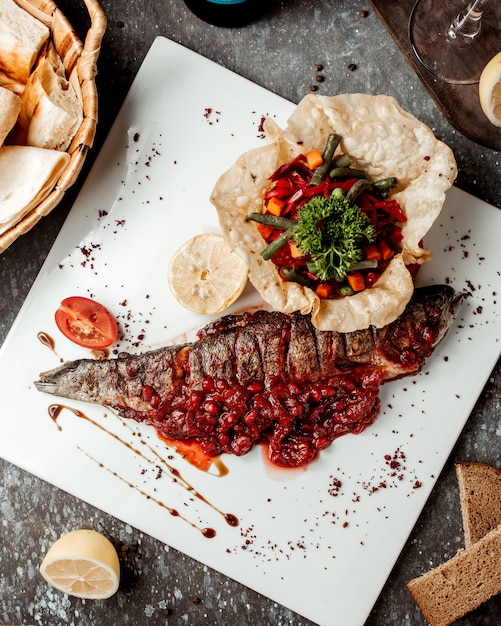 Pescado frito fresco en salsa de granada