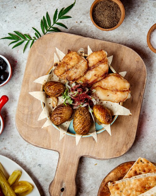 Pescado frito con papas al horno y cebolla