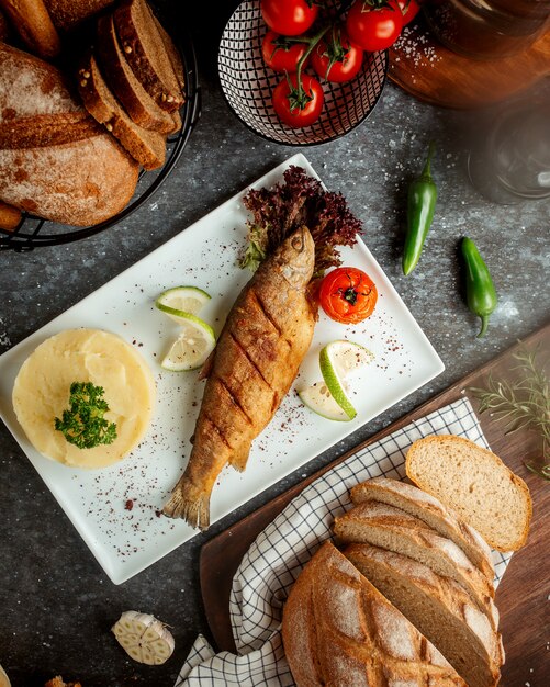 Pescado frito con puré de papa y tomate