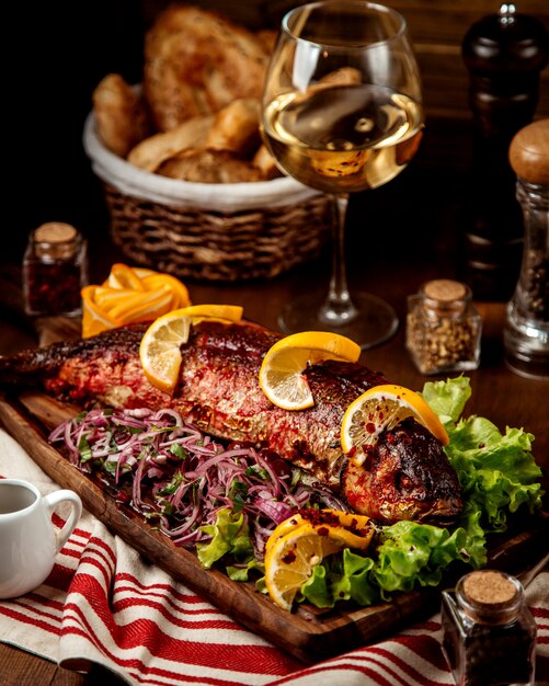 Pescado frito con rodajas de cebolla y limón.