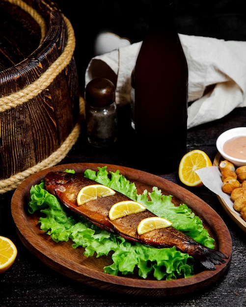 Foto gratuita pescado frito con rodajas de limón sobre la mesa