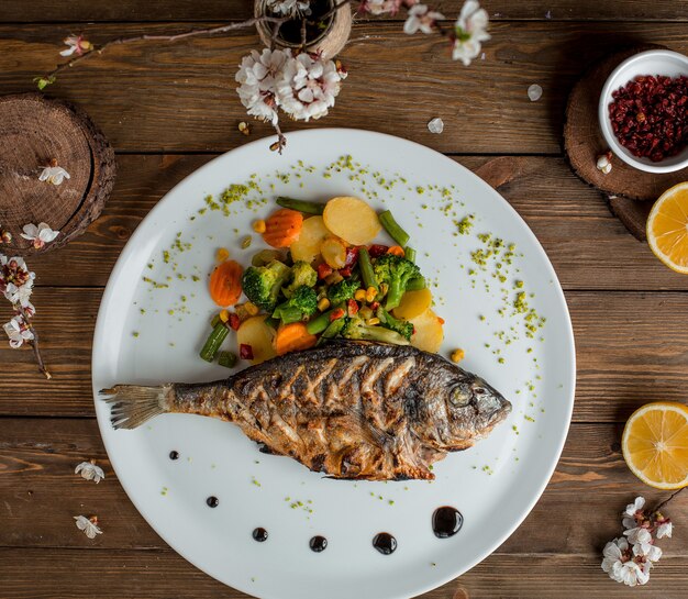 pescado frito con verduras en el plato