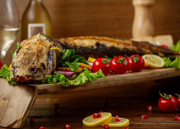 Pescado frito con verduras sobre la mesa