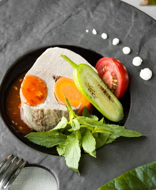 Pescado hervido con verduras sobre la mesa