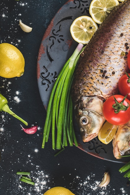 Pescado con hierbas y verduras servido con limón.