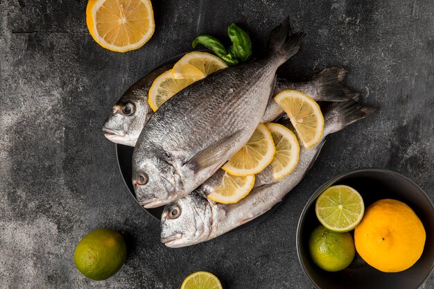 Pescado de marisco crudo con rodajas de limón vista superior