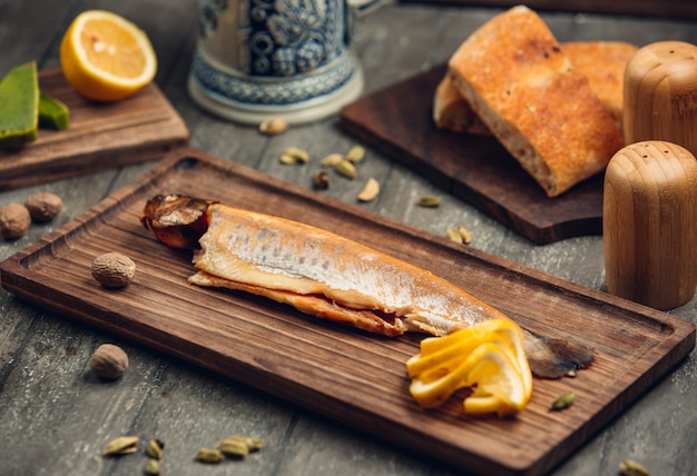 pescado en la tabla de madera con limón