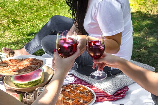 Picnic de verano con amigos en la naturaleza con comida y bebida.