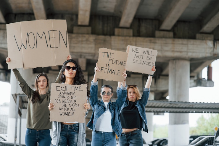 Foto gratuito de pie debajo del puente. grupo de mujeres feministas al aire libre protesta por sus derechos