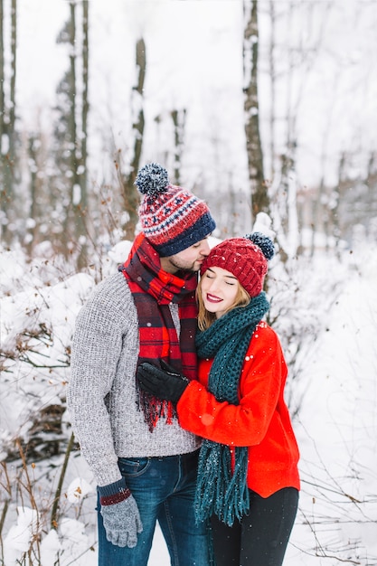 Pie de la pareja con estilo en el bosque nevado