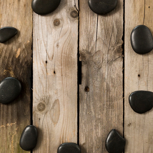 Foto gratuita piedra negra del guijarro que forma forma circular en la tabla oxidada