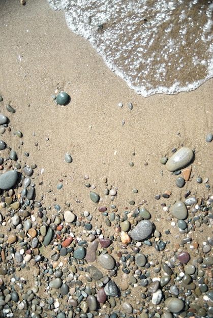 Piedras de arena y ola de agua.