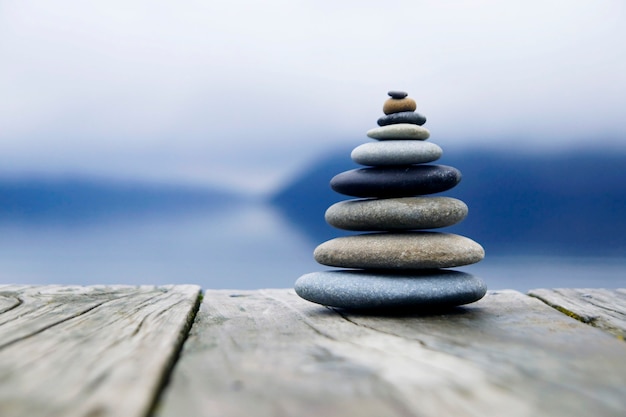 Piedras de equilibrio zen junto a un lago brumoso