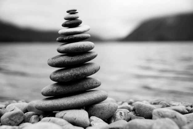 Piedras de equilibrio zen junto a un lago brumoso