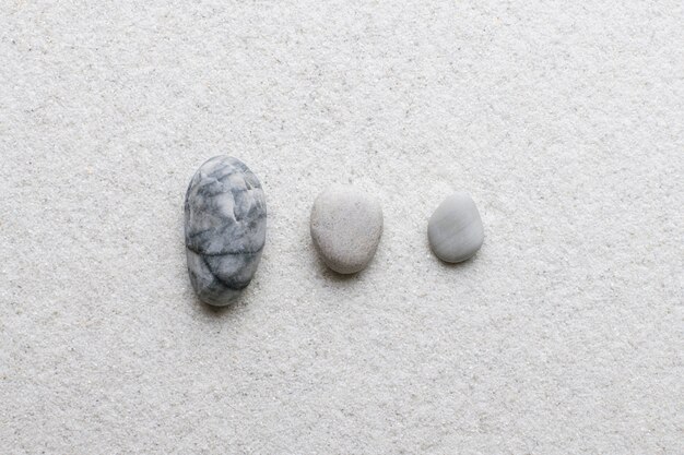 Piedras de mármol zen apiladas sobre fondo blanco en concepto de estabilidad
