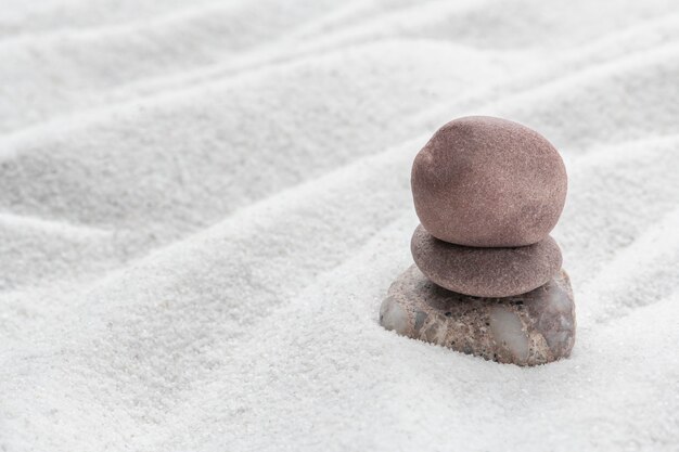 Piedras zen apiladas fondo de arena arte del concepto de equilibrio