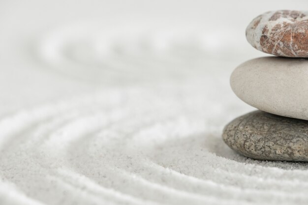 Piedras zen apiladas fondo de arena arte del concepto de equilibrio