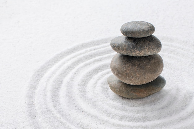 Piedras zen apiladas fondo de arena arte del concepto de equilibrio