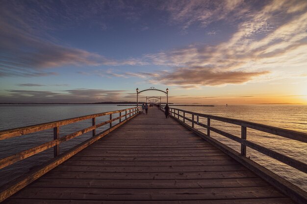 Pier y el mar azul durante una pintoresca puesta de sol