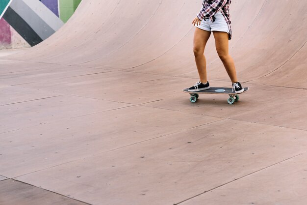 Piernas de chica skating en medio tubo